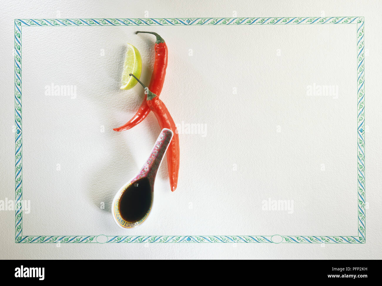 Red Chilli Peppers with a Lime Segment and a spoonful of Soy sauce Stock Photo