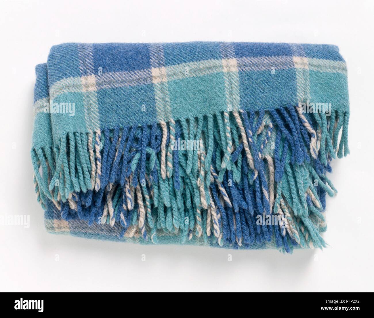 Folded blue and white tartan wool blanket with fringing Stock Photo
