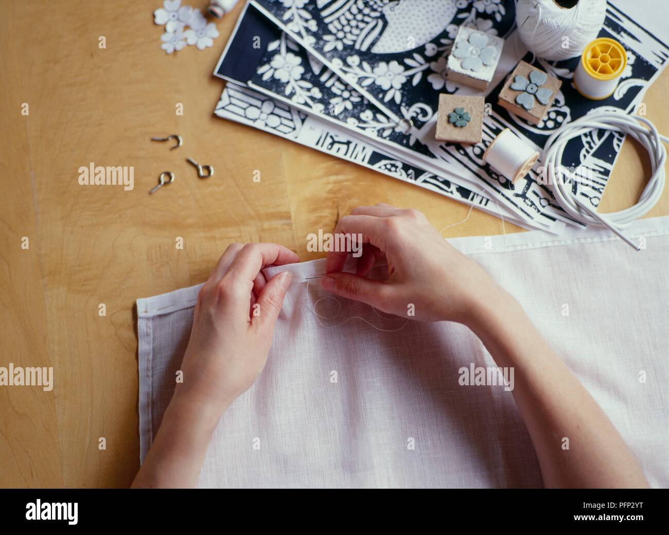 Sewing hem of a muslin curtain, closeup Stock Photo Alamy