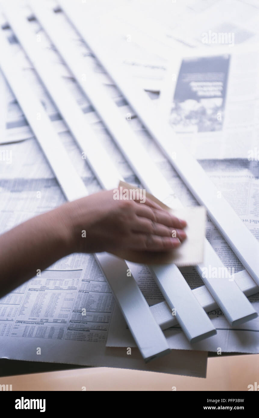 Rubbing painted wood surface using fine grade sandpaper, closeup Stock