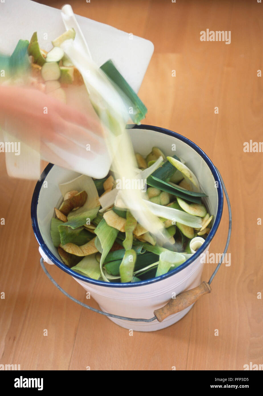 Moving fruit and vegetable peelings from chopping board into metal