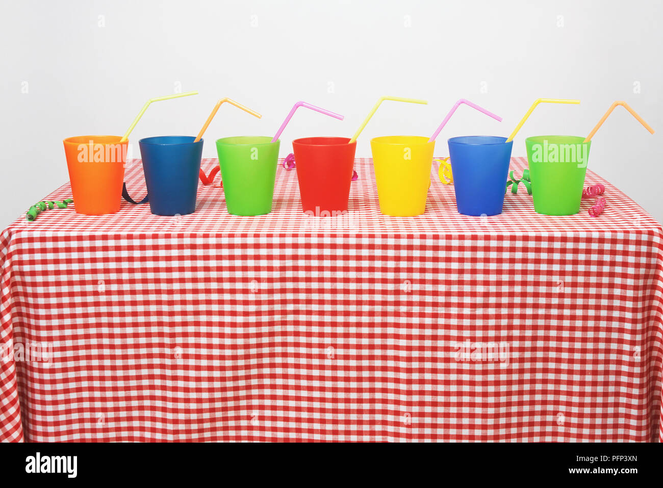 Seven plastic cups with drinking straws Stock Photo