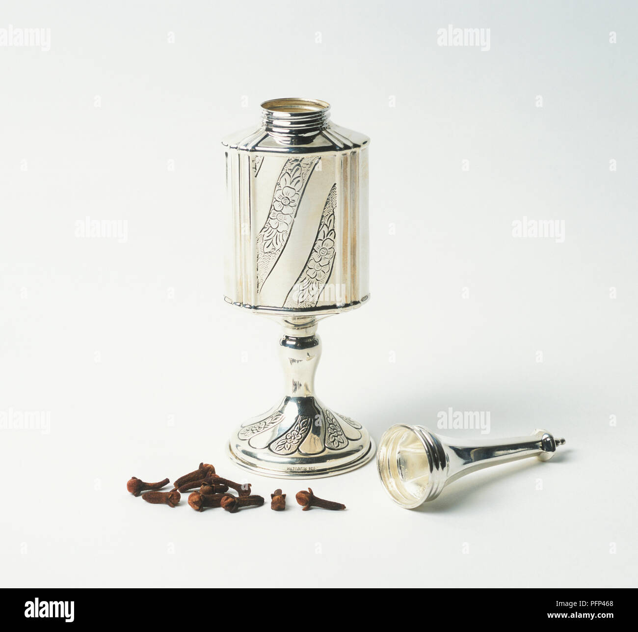 Dried cloves by opened silver spice container used for Jewish Sabbath