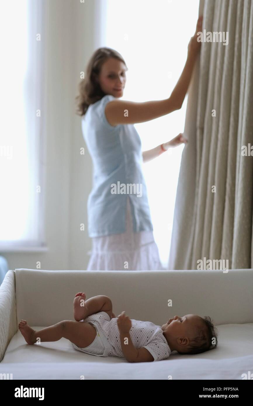Woman pulling back a curtain hires stock photography and images Alamy