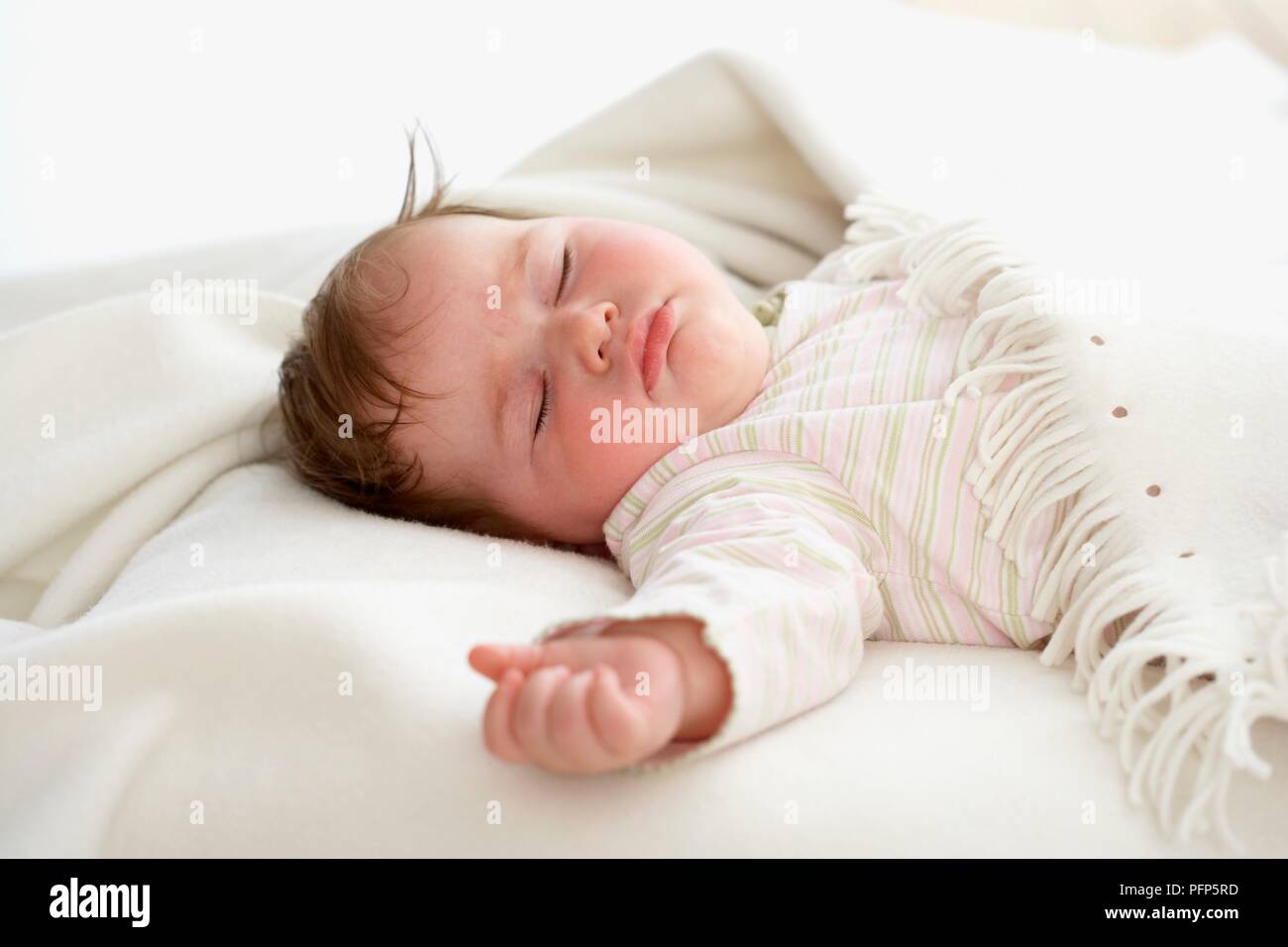 Baby girl asleep covered with blanket Stock Photo