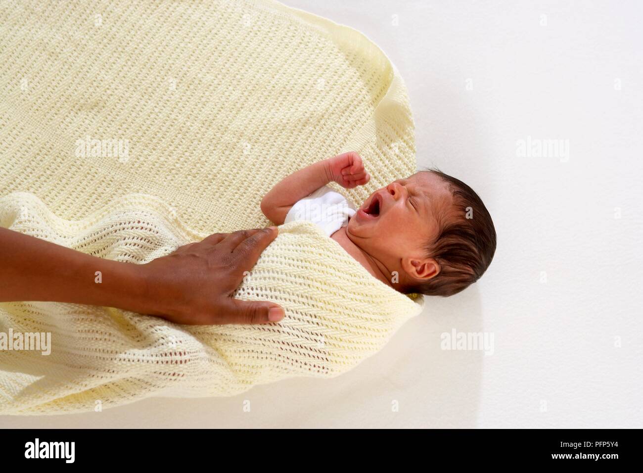 Baby boy being wrapped in baby blanket Stock Photo