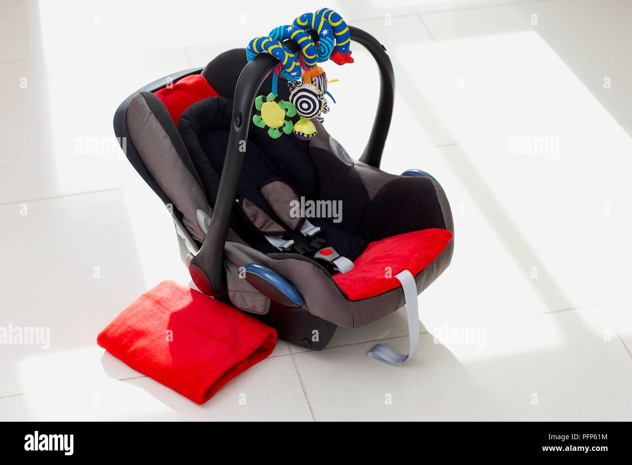Baby car seat and folded blanket on floor Stock Photo