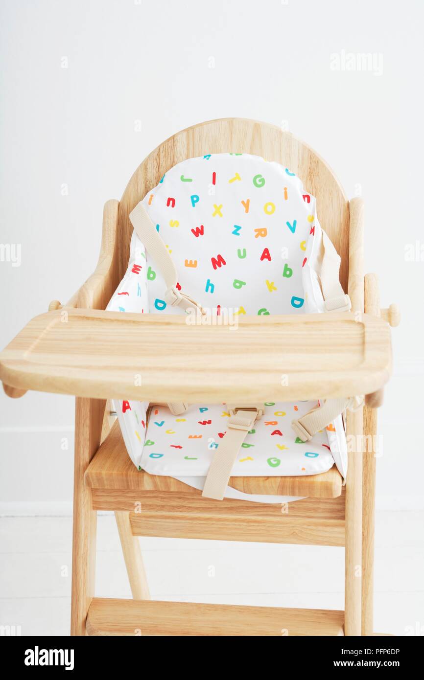 Wooden high chair with seat pad Stock Photo Alamy