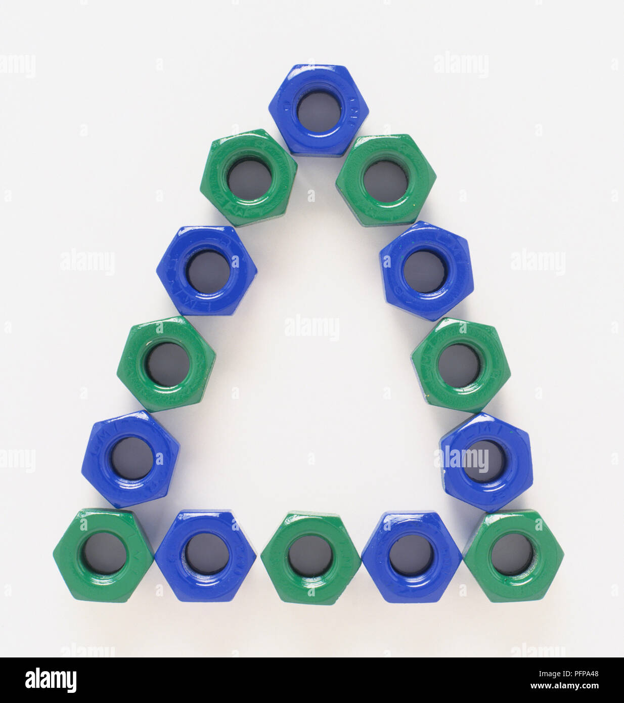 Plastic green and blue nuts arranged to form a triangle, closeup Stock
