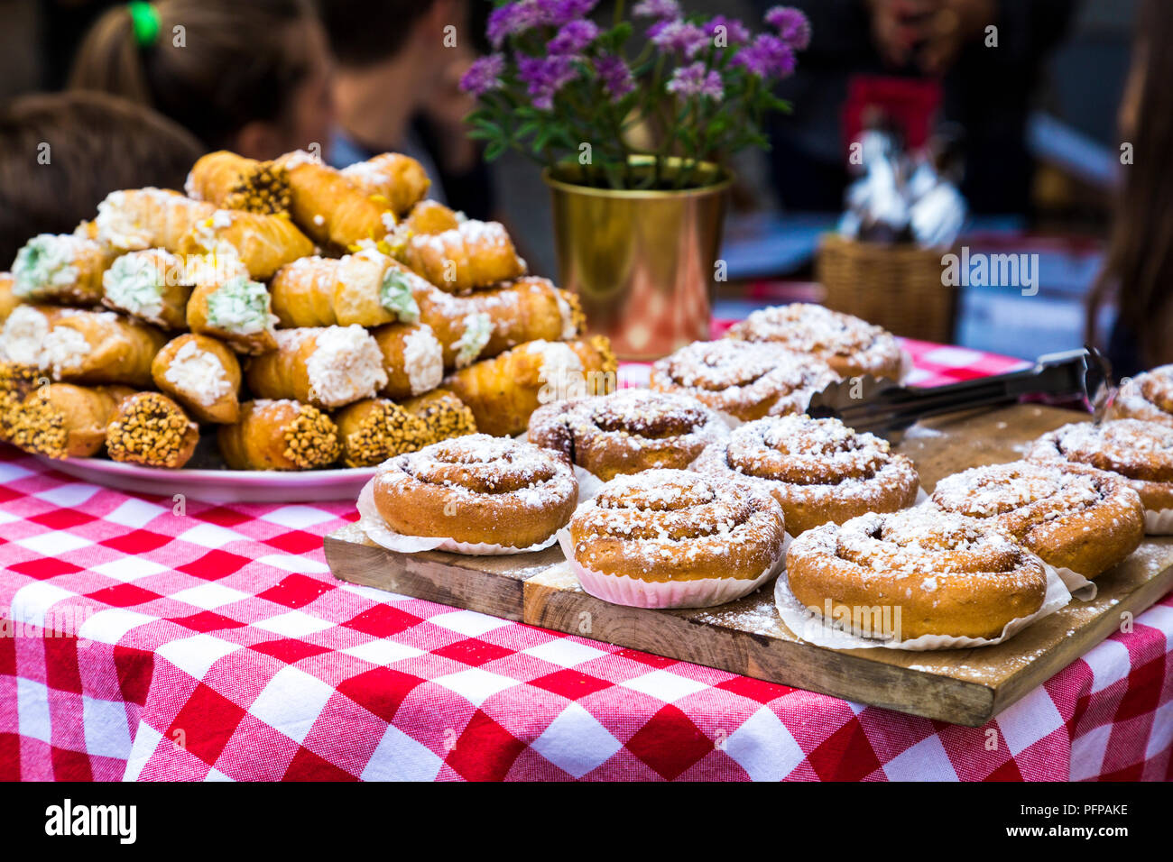 Delicious Swedish cinnamon buns (Kanelbullar) on a wooden board in Stockholm Old Town, Sweden Stock Photo