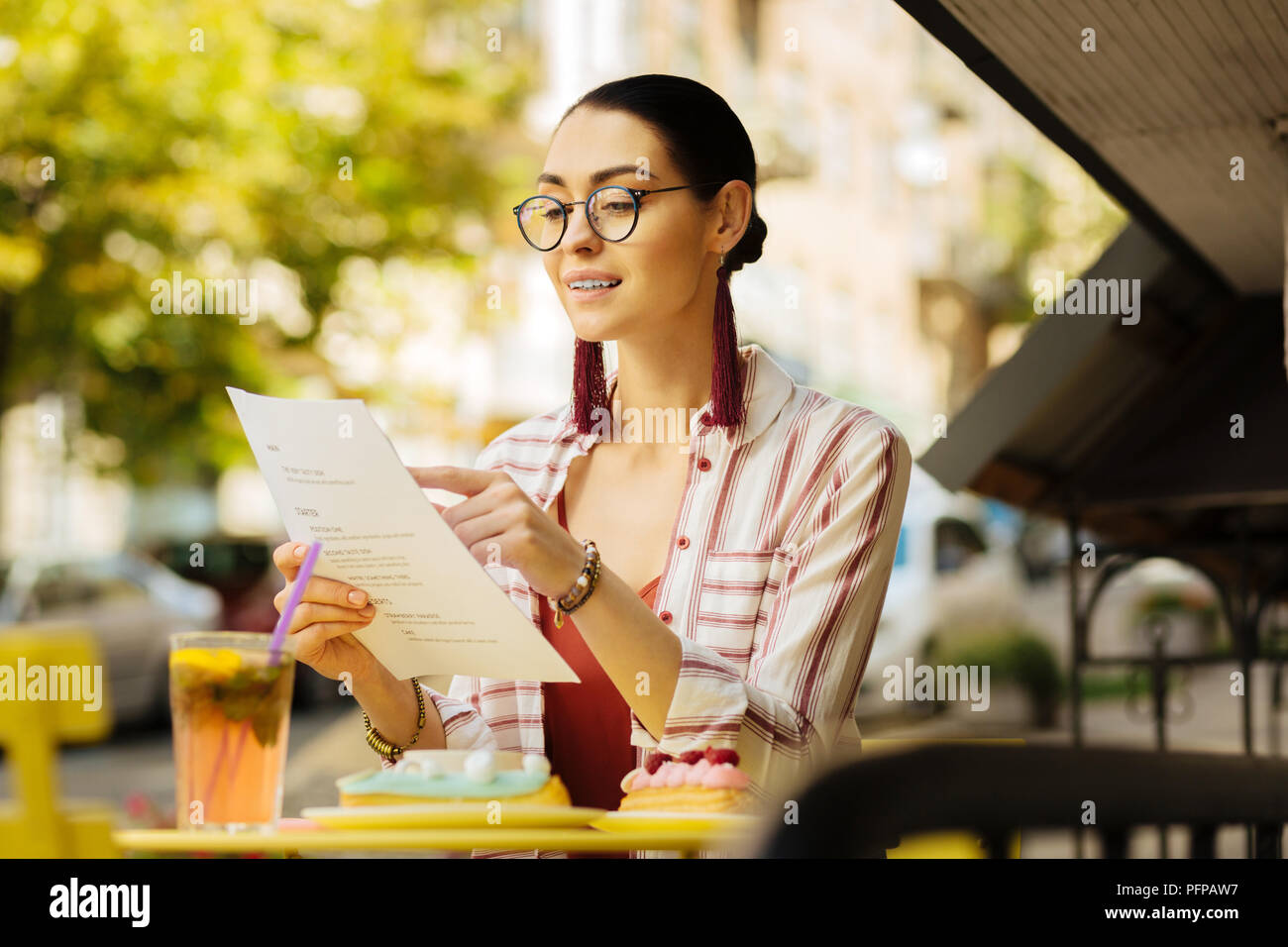 Young woman smiling and pointing to the meals in a menu Stock Photo