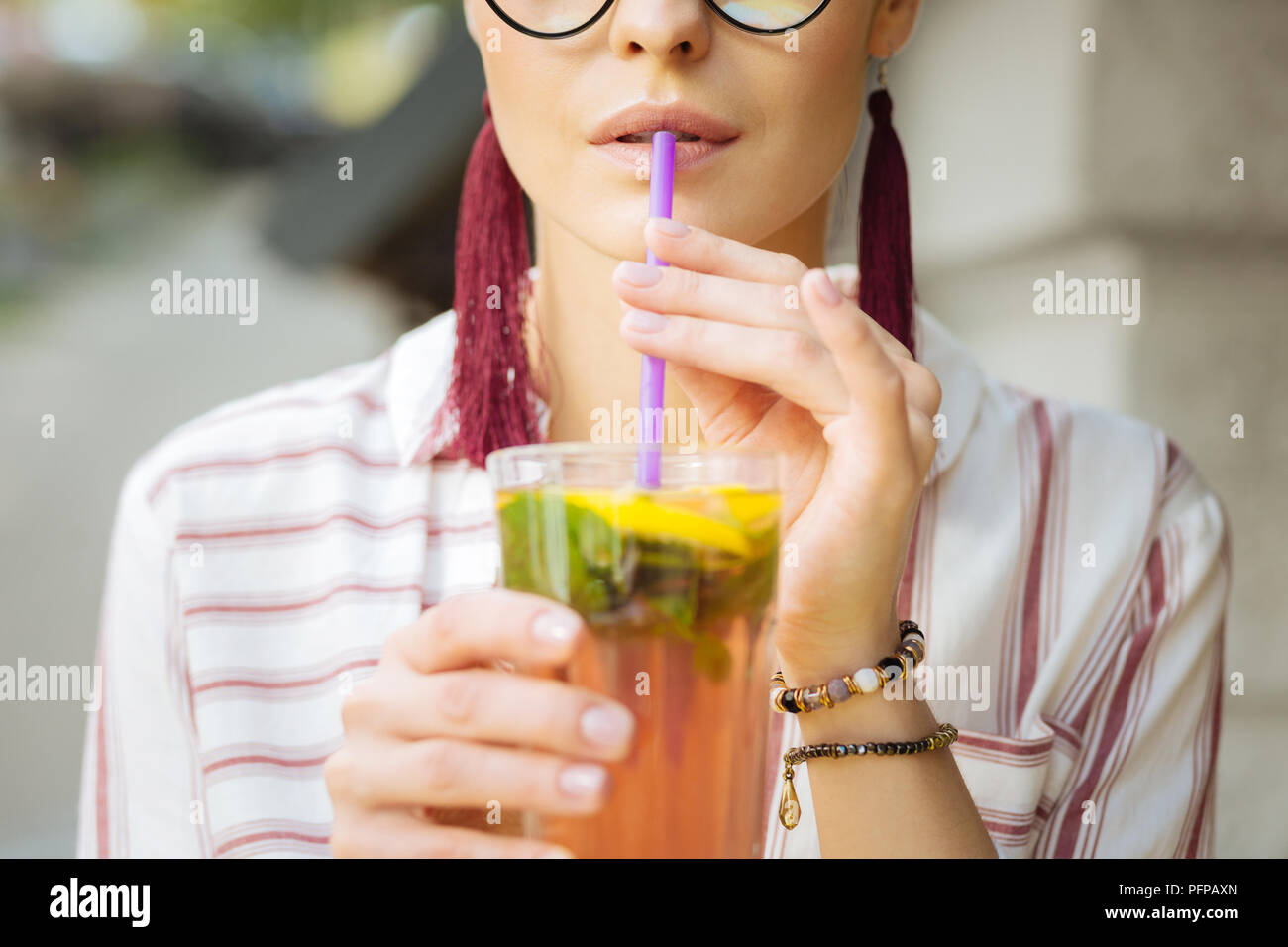 Close up of a woman drinking lemonade with a straw Stock Photo