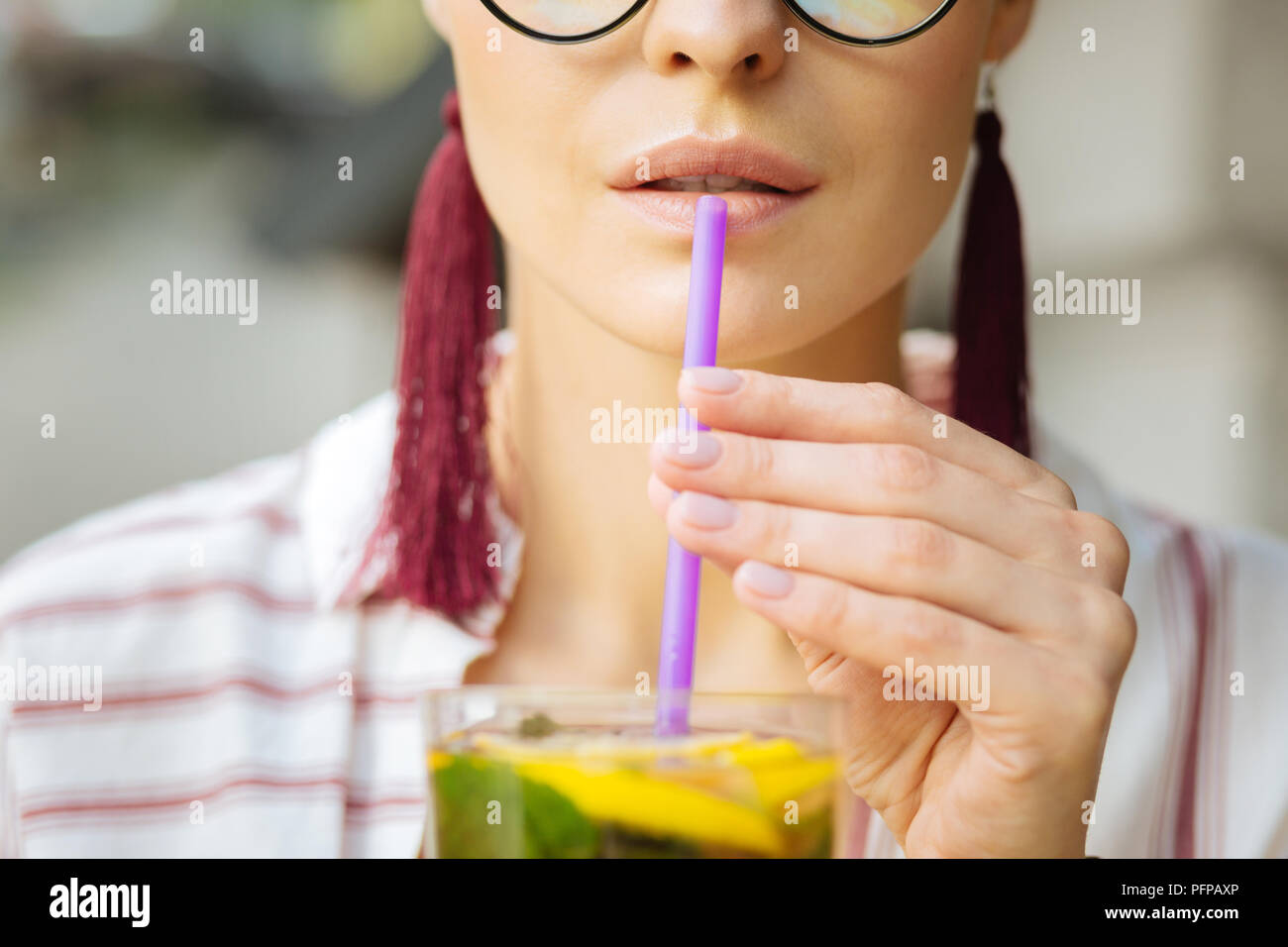 Close up of a sipping straw in a hand of a woman Stock Photo