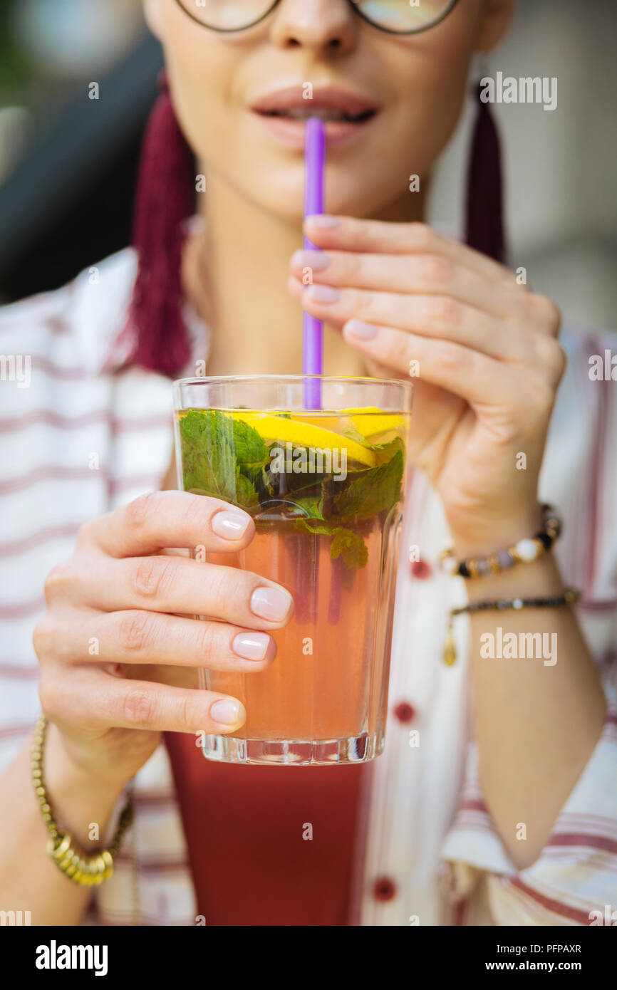 Young person sitting alone and drinking lemonade with a straw Stock Photo