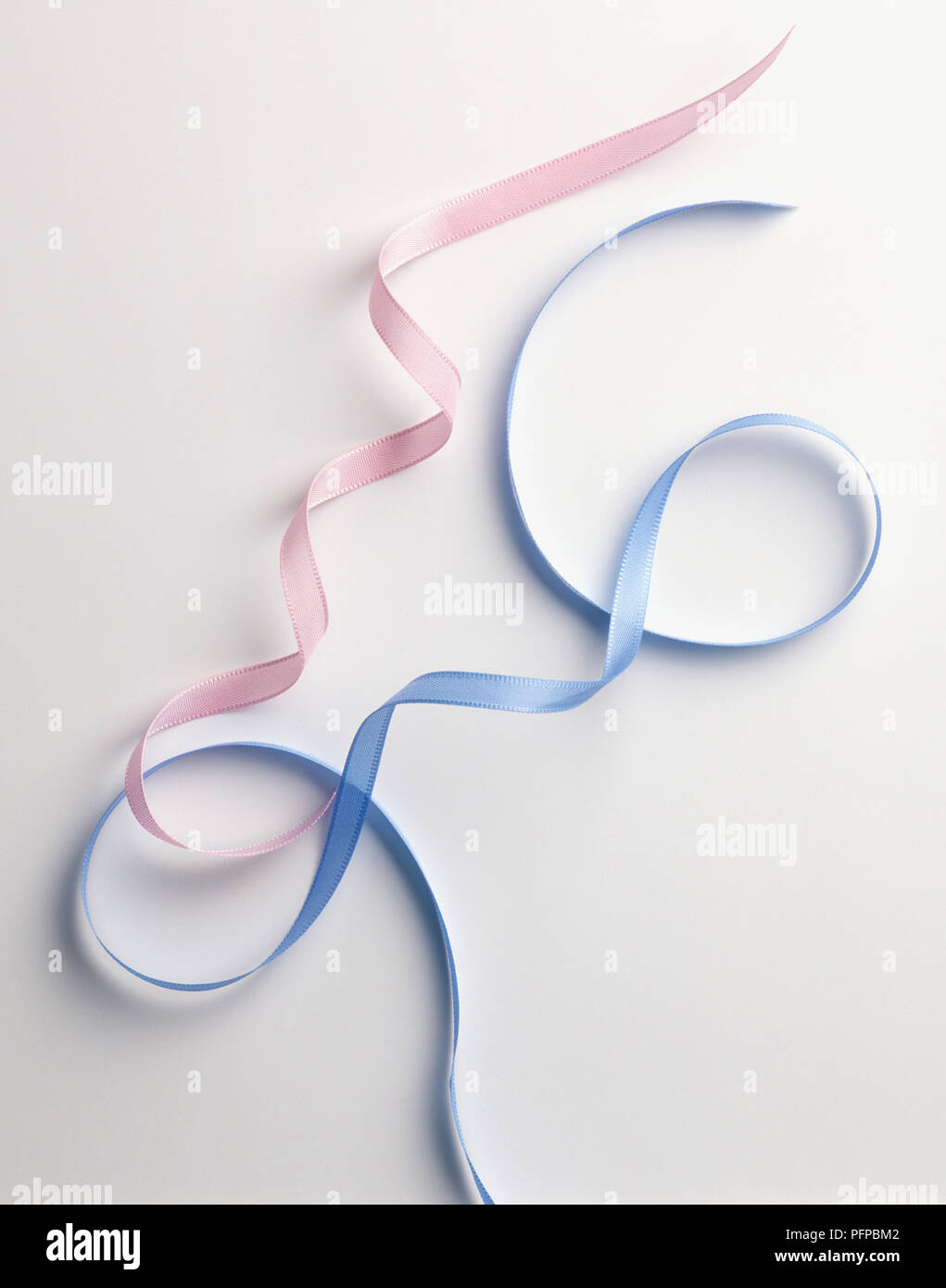 Two curled ribbons, pink and blue Stock Photo - Alamy