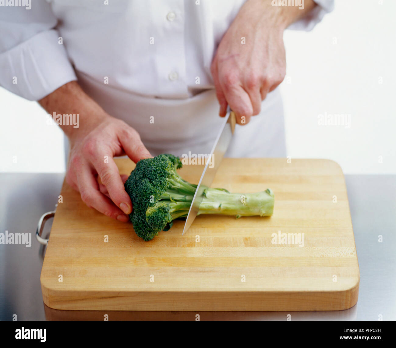 Using Kitchen Knife To Cut Stem From Broccoli Stock Photo Alamy