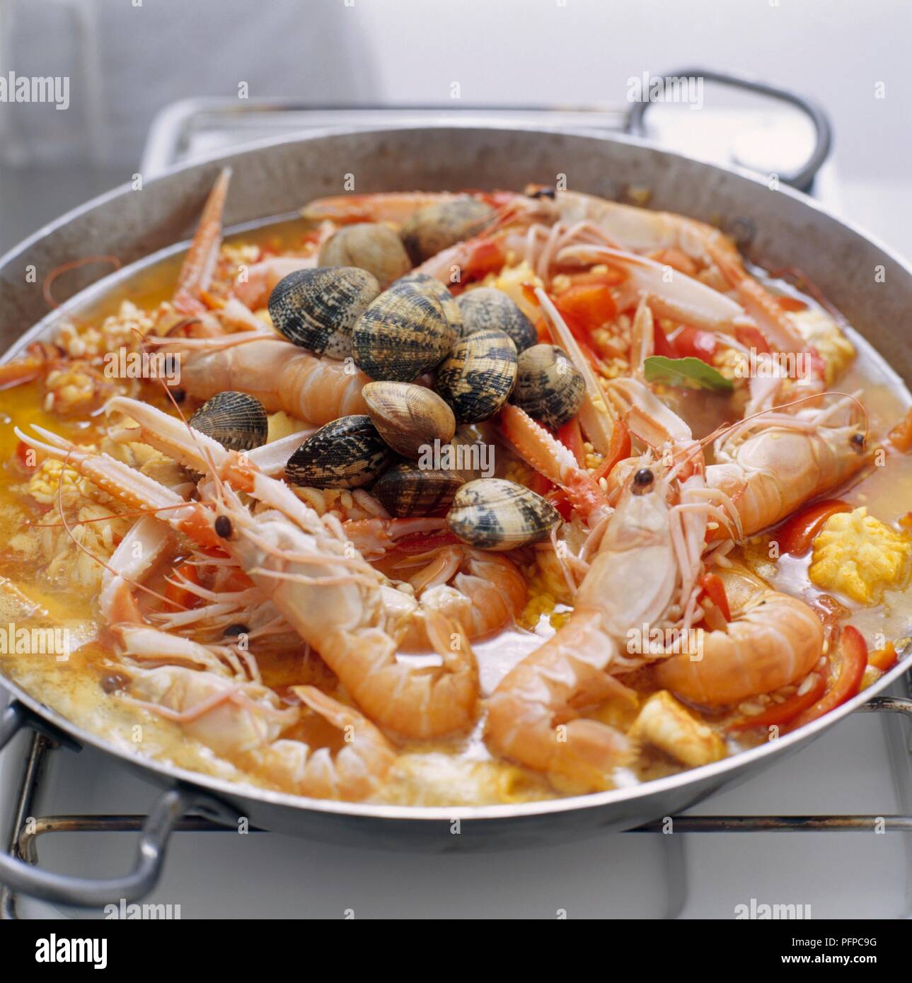 Paella cooking in pan on gas hob Stock Photo Alamy