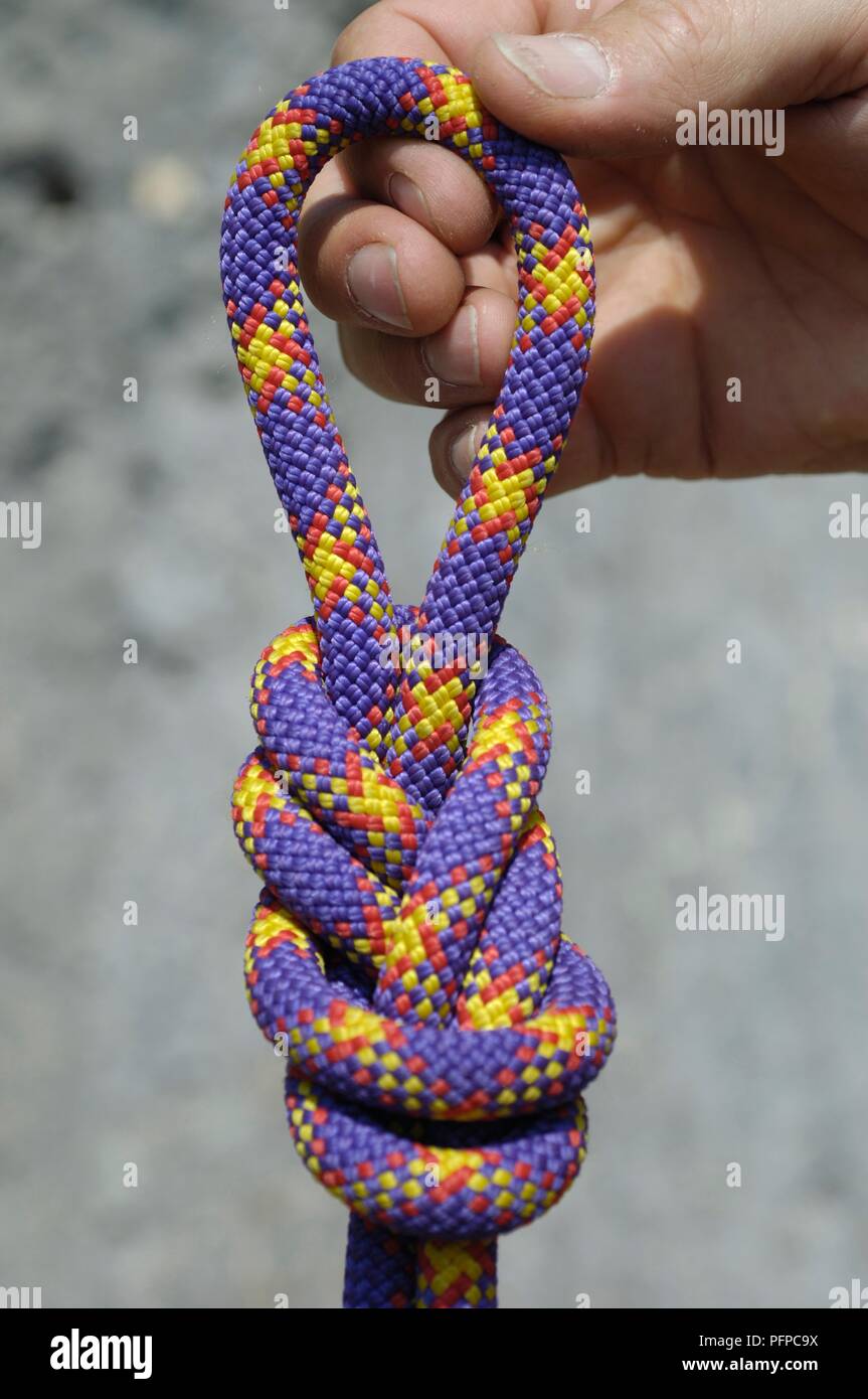 Hand holding figureofeight knot in climbing rope Stock Photo Alamy