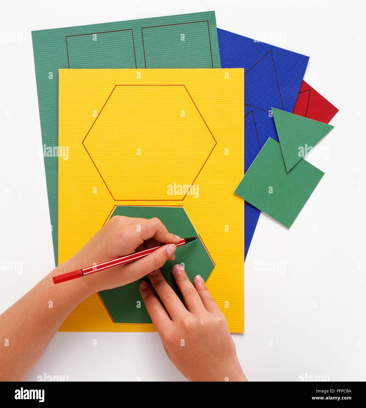 Child drawing hexagon shapes on coloured paper, close-up Stock Photo - Alamy