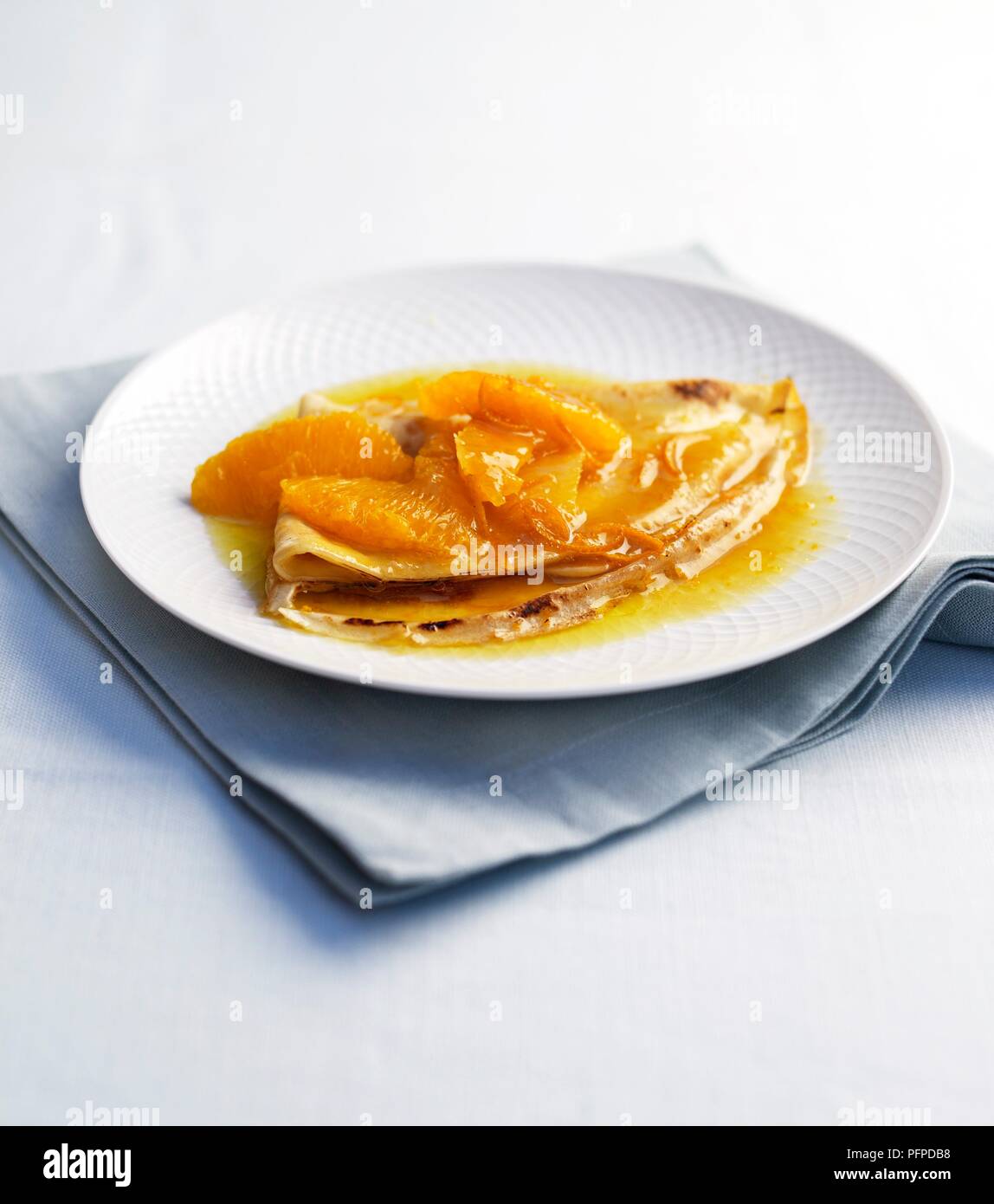 Crepe suzette with orange served on white plate on folded napkin Stock Photo