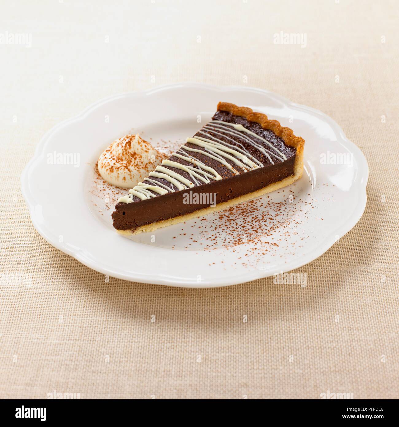 Slice of chocolate pie on white plate with cream Stock Photo