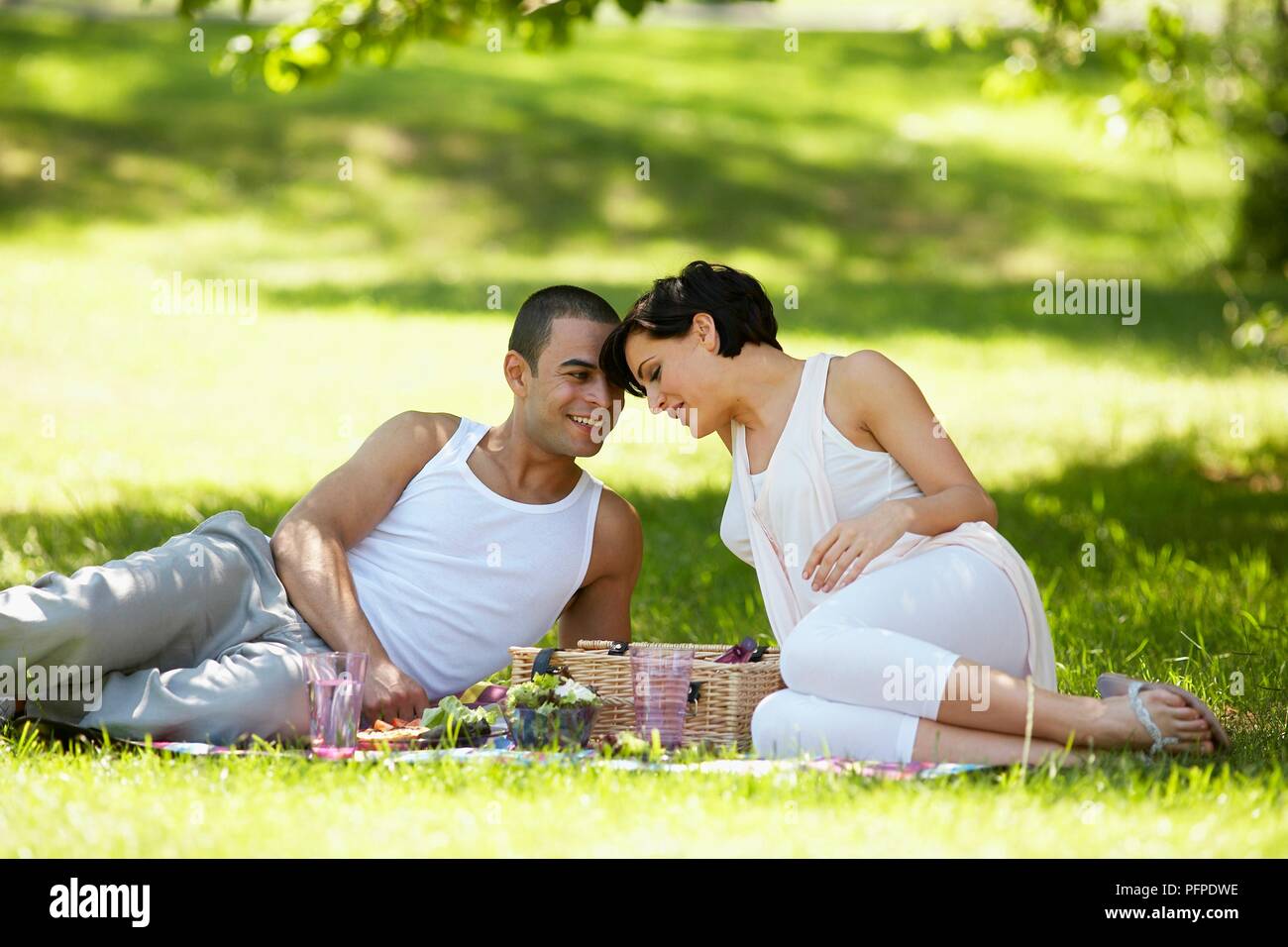 Young couple having picnic in park Stock Photo - Alamy