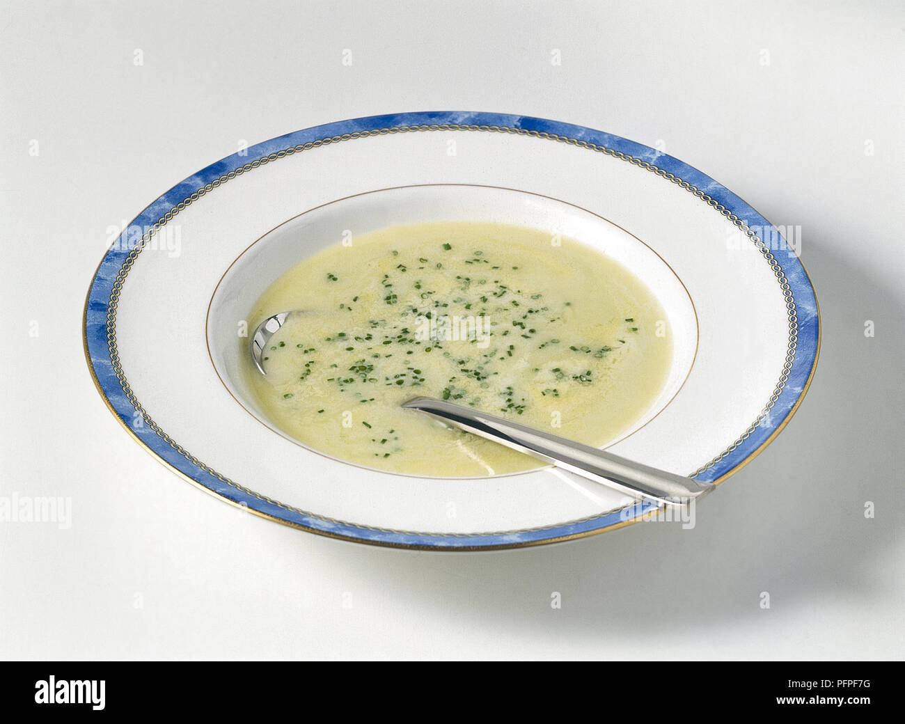 Bowl of leek and potato soup with herbs, spoon Stock Photo