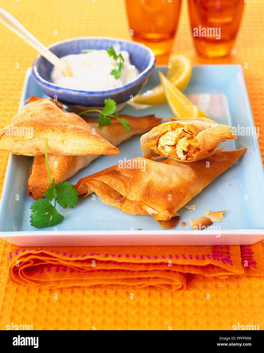 Saffron feta filo triangles served with Greek yoghurt Stock Photo Alamy
