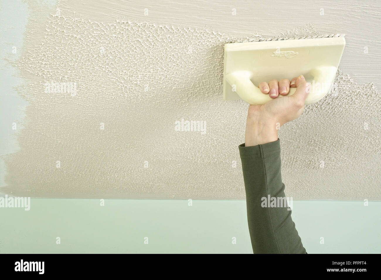 Using a stippler to create a stippled surface in plaster on a ceiling Stock Photo Alamy