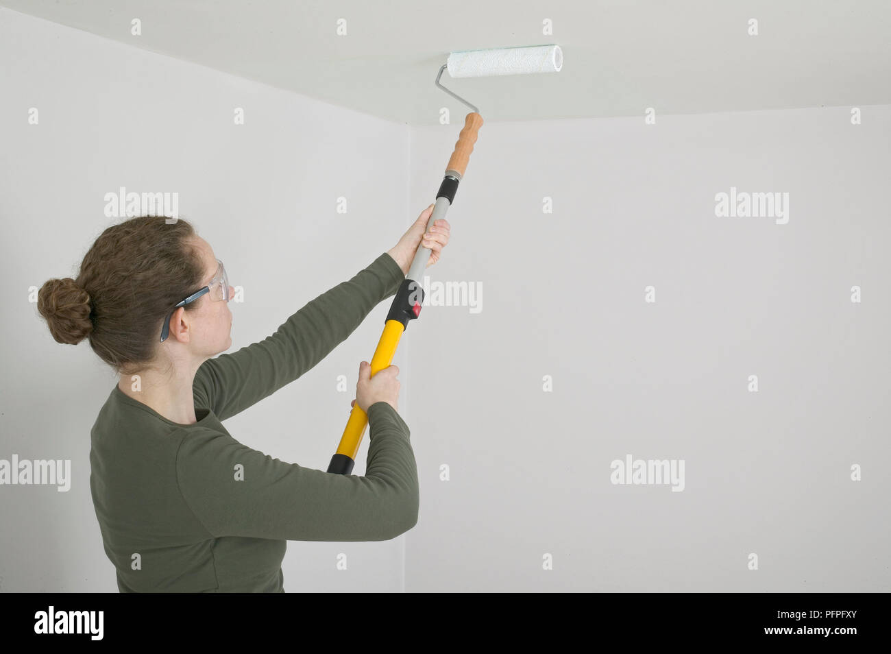 Woman Painting Ceiling With Roller Stock Photo 216239715