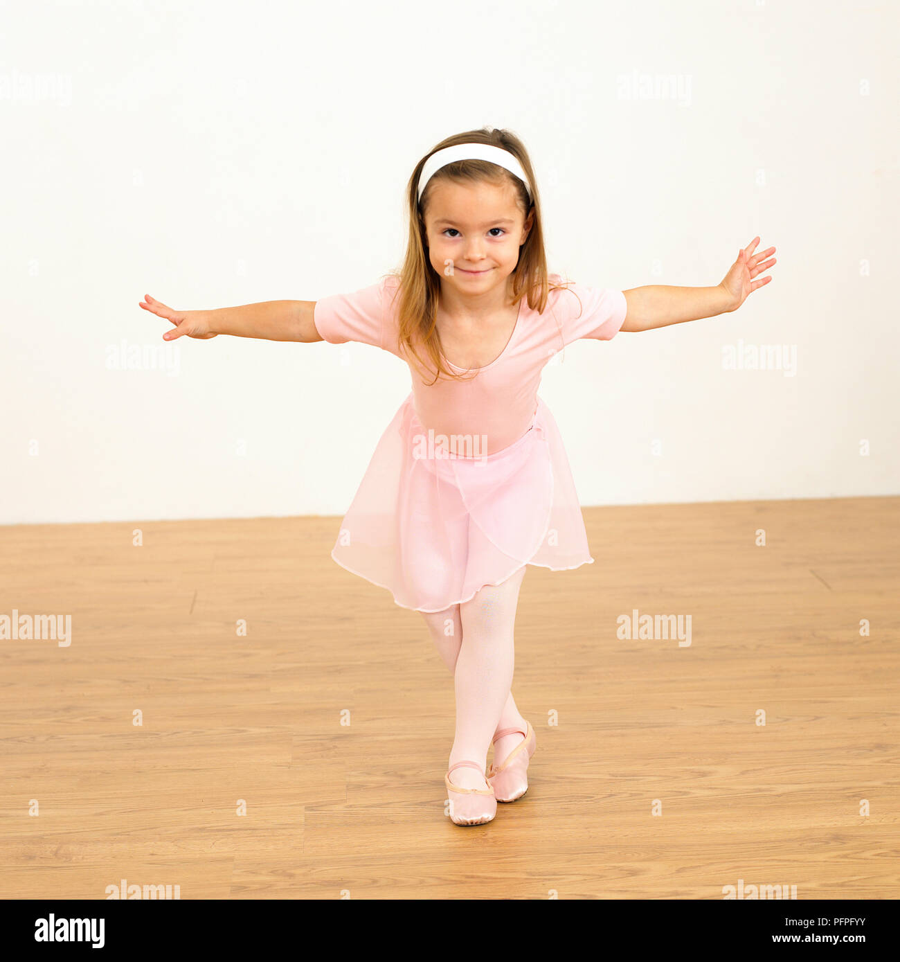 Girl in ballerina outfit with arms outstretched, 5 years old Stock Photo