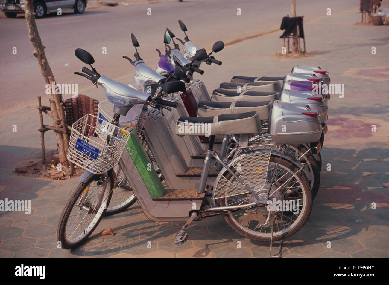 Cambodia, Siem Reap, row of electric bicycles for hire parked in street Stock Photo