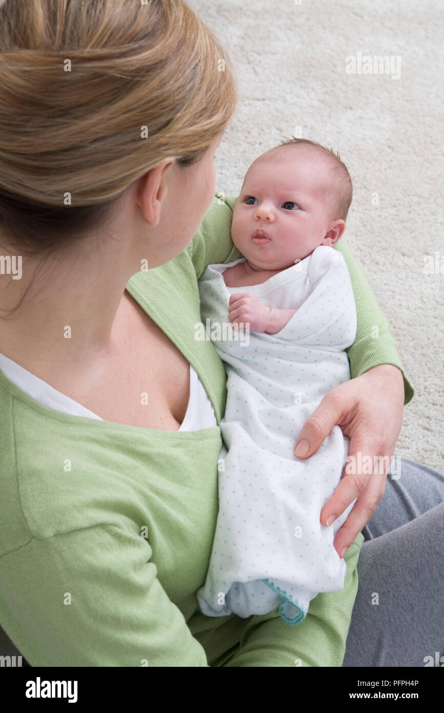 Mother holding tiny swaddled baby in her arms Stock Photo Alamy