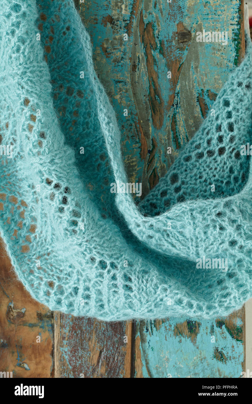 Lace-patterned, turquoise wrap against wood background Stock Photo