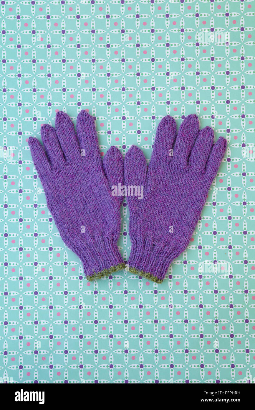 Purple gloves on patterned background Stock Photo