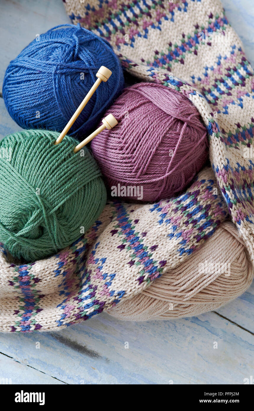 Balls of wool, knitting needles, and knitted sleeves of fair-isle cardigan Stock Photo