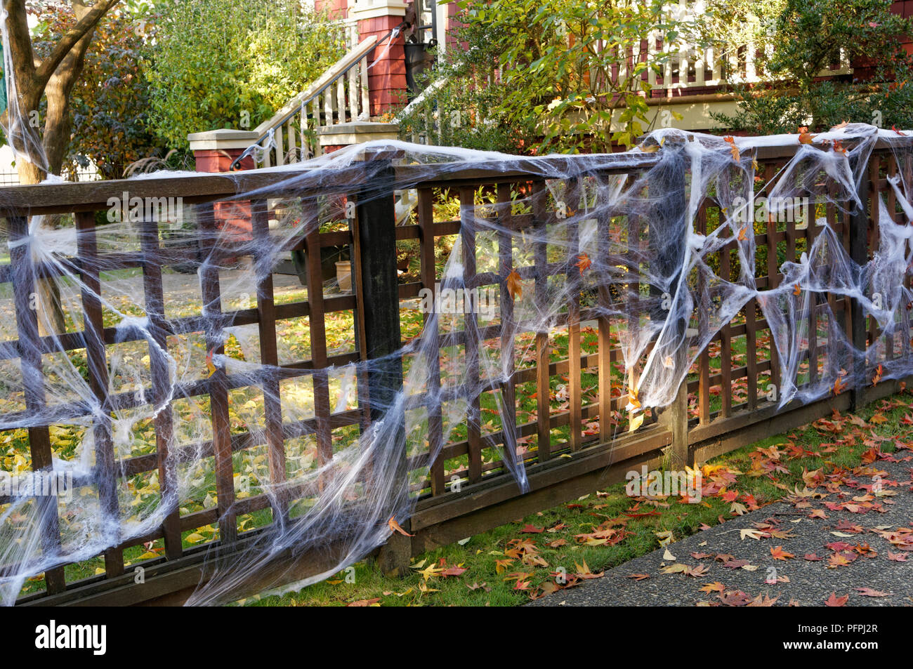 White Halloween spider webs decorating the fence of a house Stock Photo