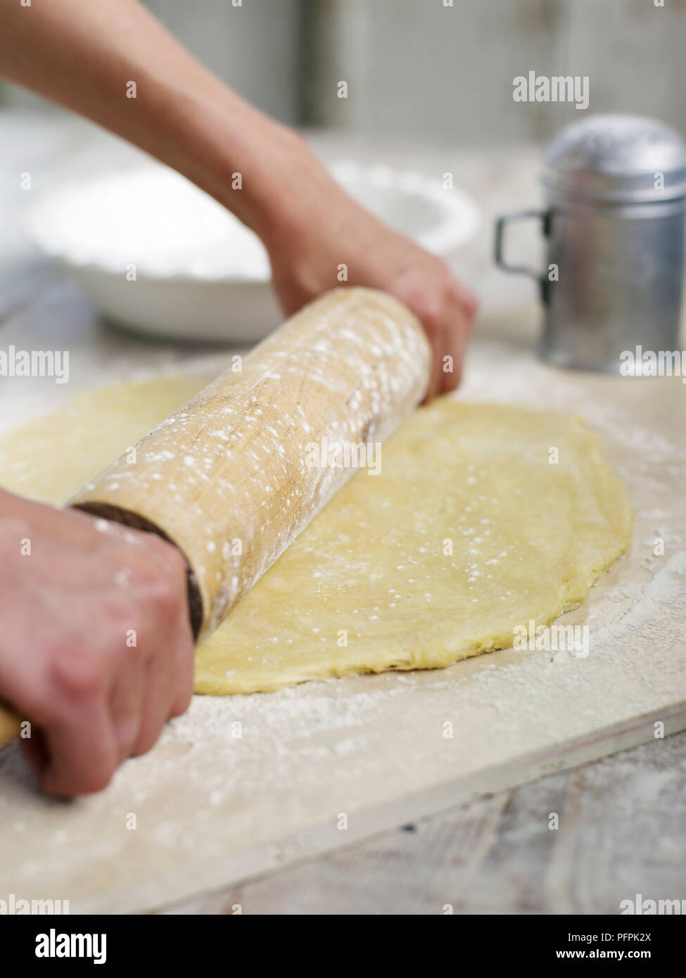 Rolling out pie pastry on floured wooden board Stock Photo