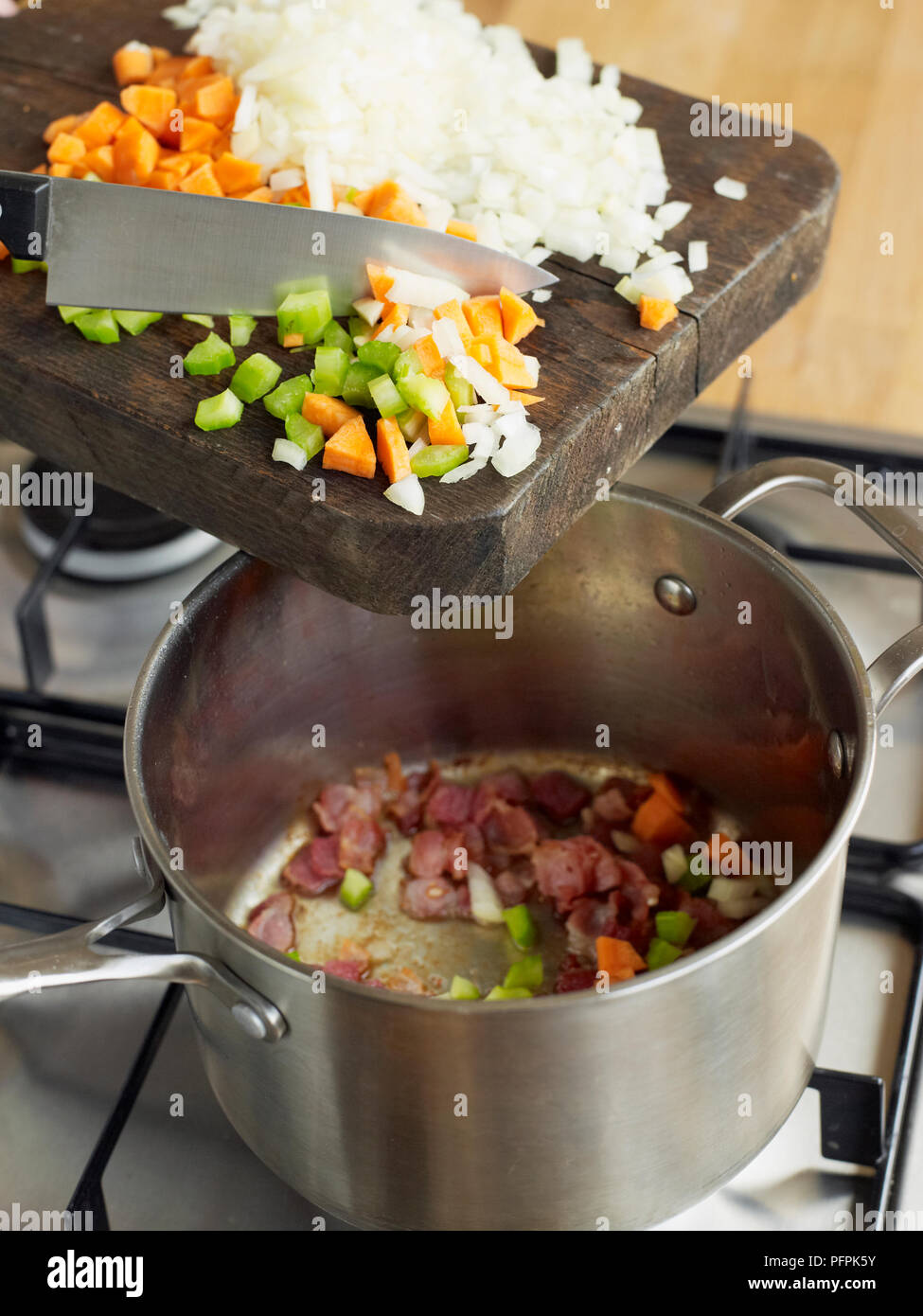 Adding ingredients to pan to make espagnole sauce Stock Photo