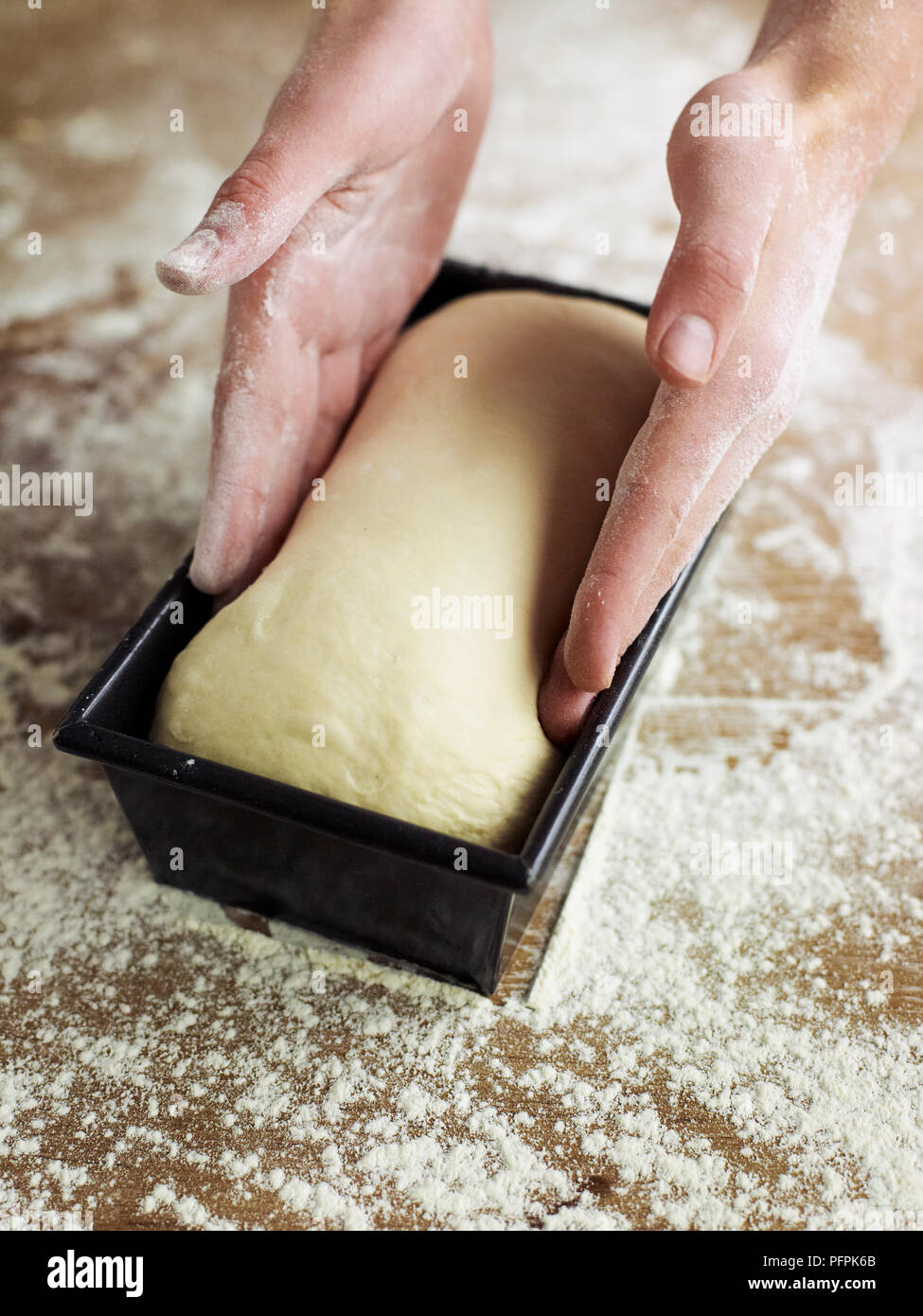 Placing partially risen bread dough in loaf tin Stock Photo Alamy
