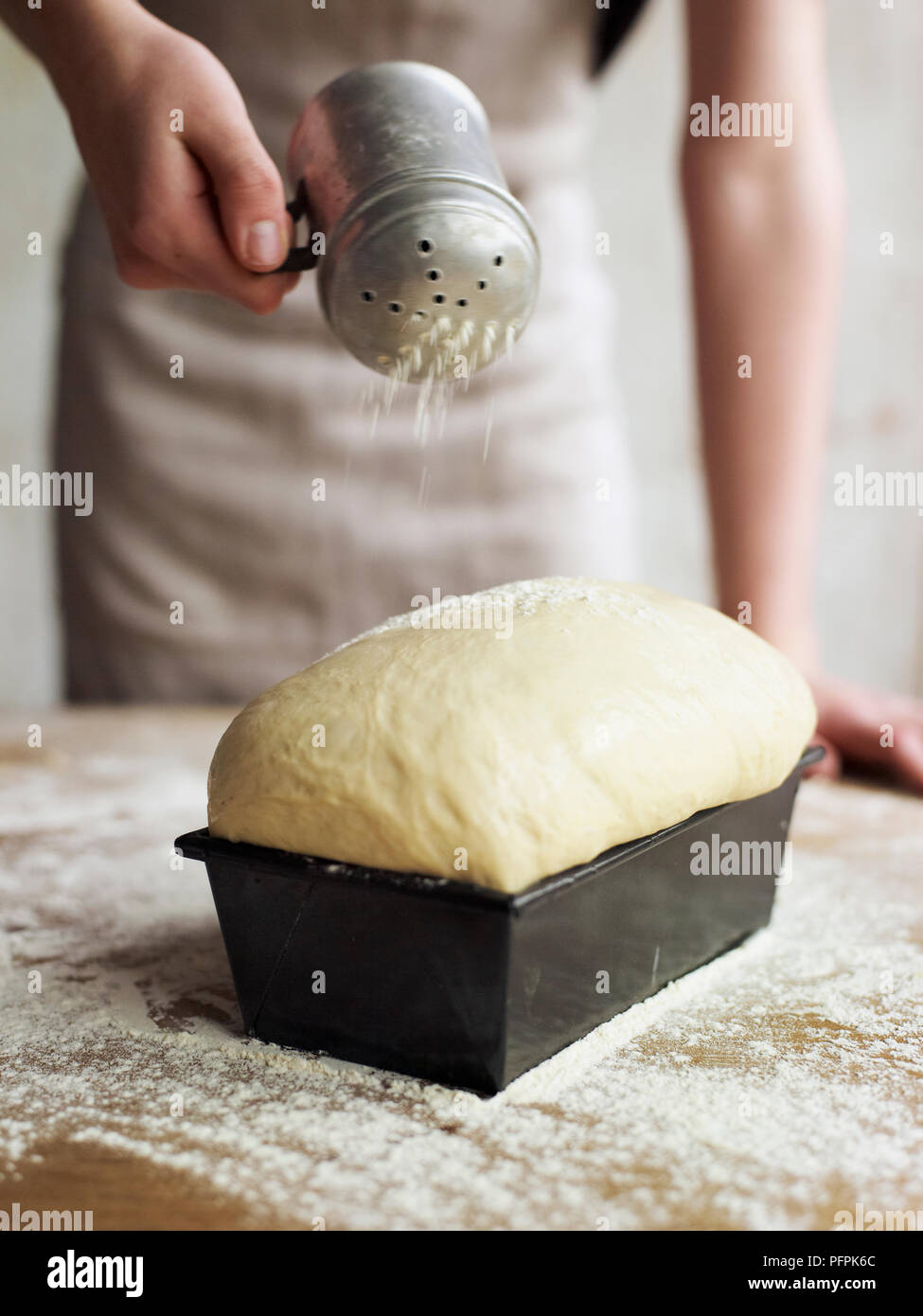 Sprinkling risen bread dough with flour Stock Photo