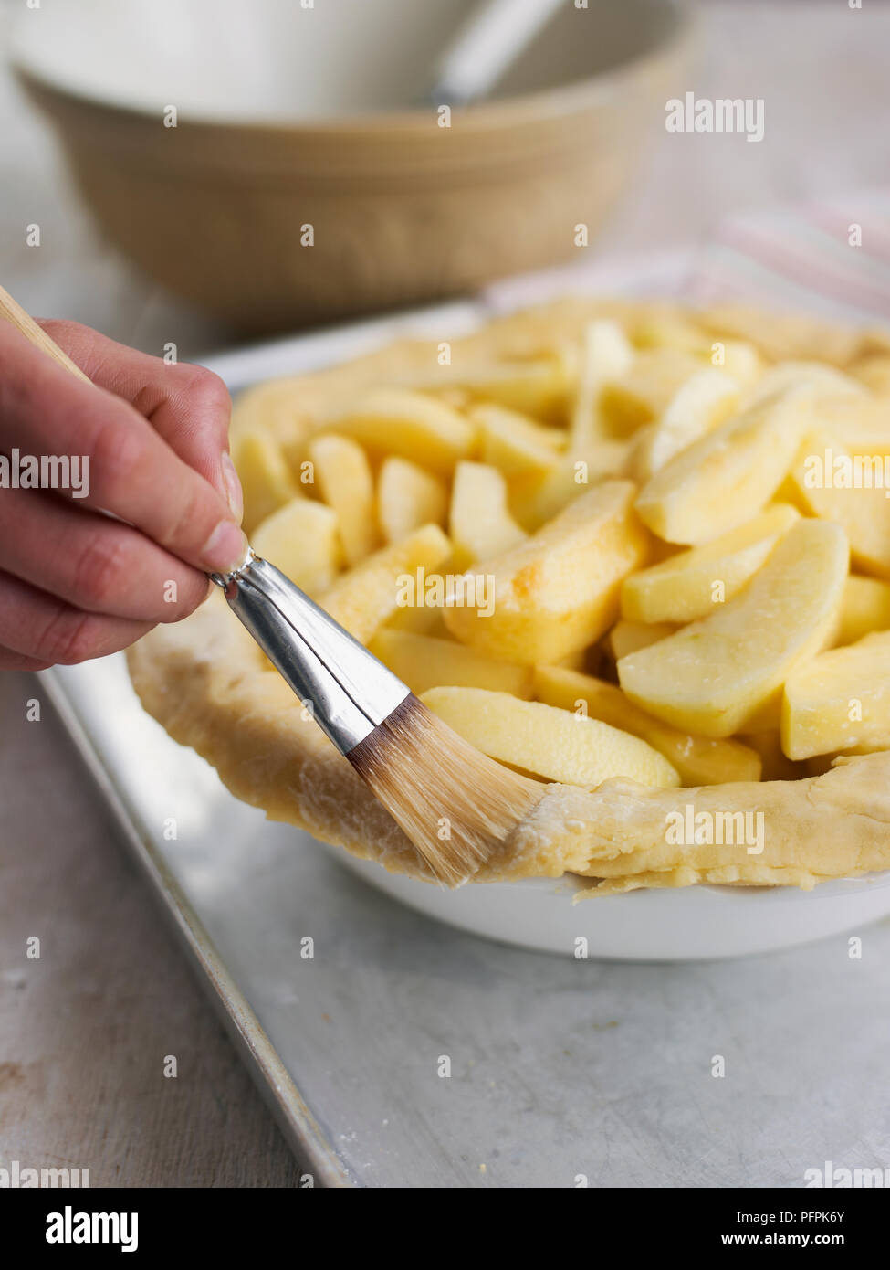 Brushing pastry edge with water (making apple pie) Stock Photo