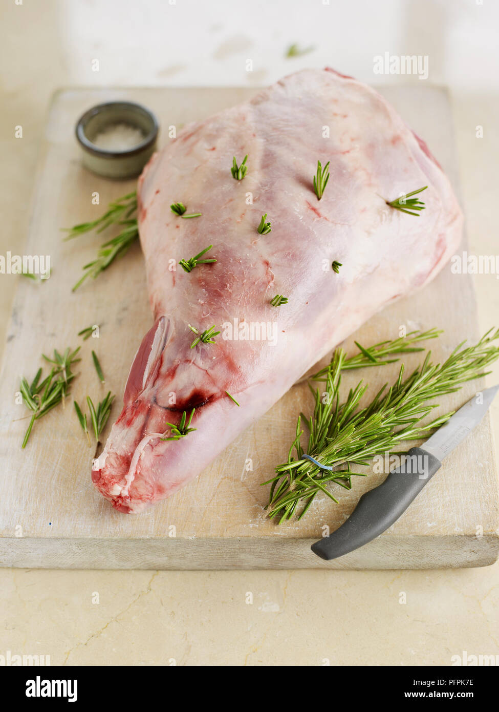 Leg of lamb studded with sprigs of rosemary Stock Photo