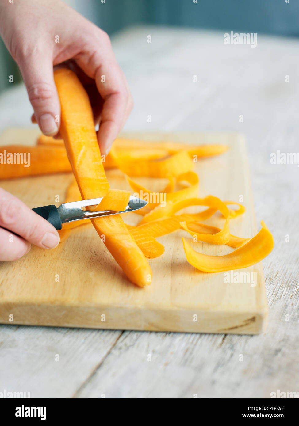 Paring carrot with vegetable peeler Stock Photo