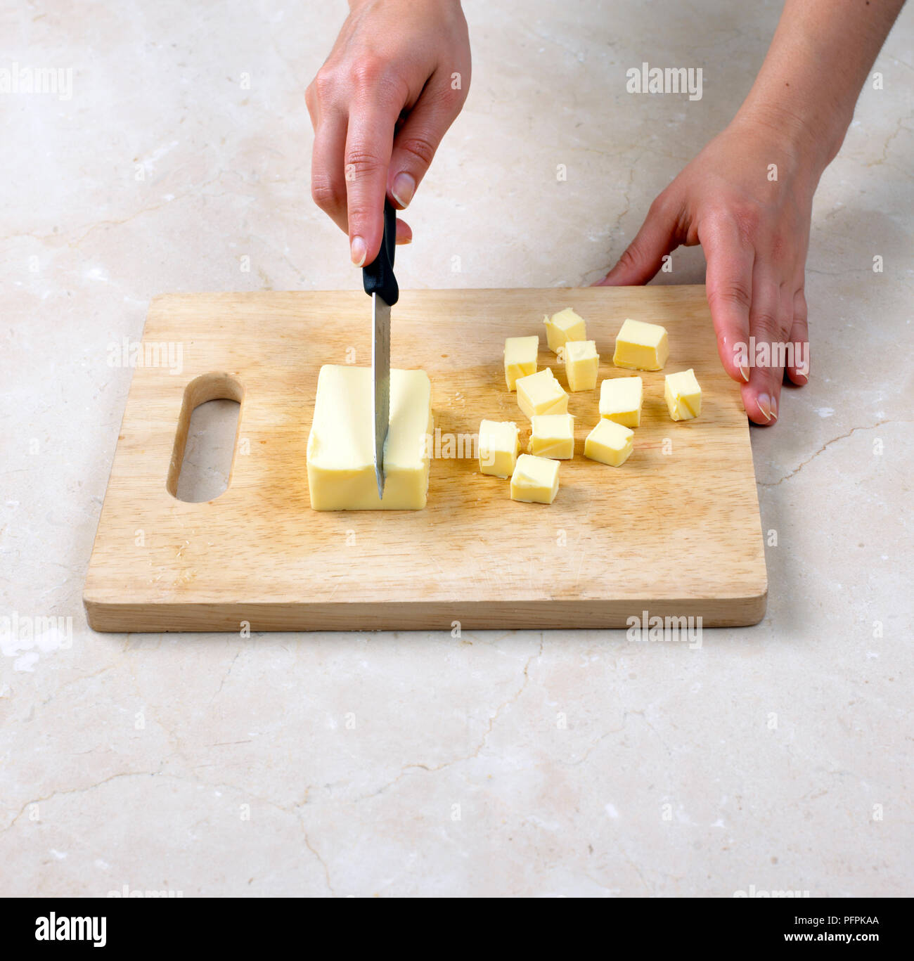 Cutting butter into cubes Stock Photo