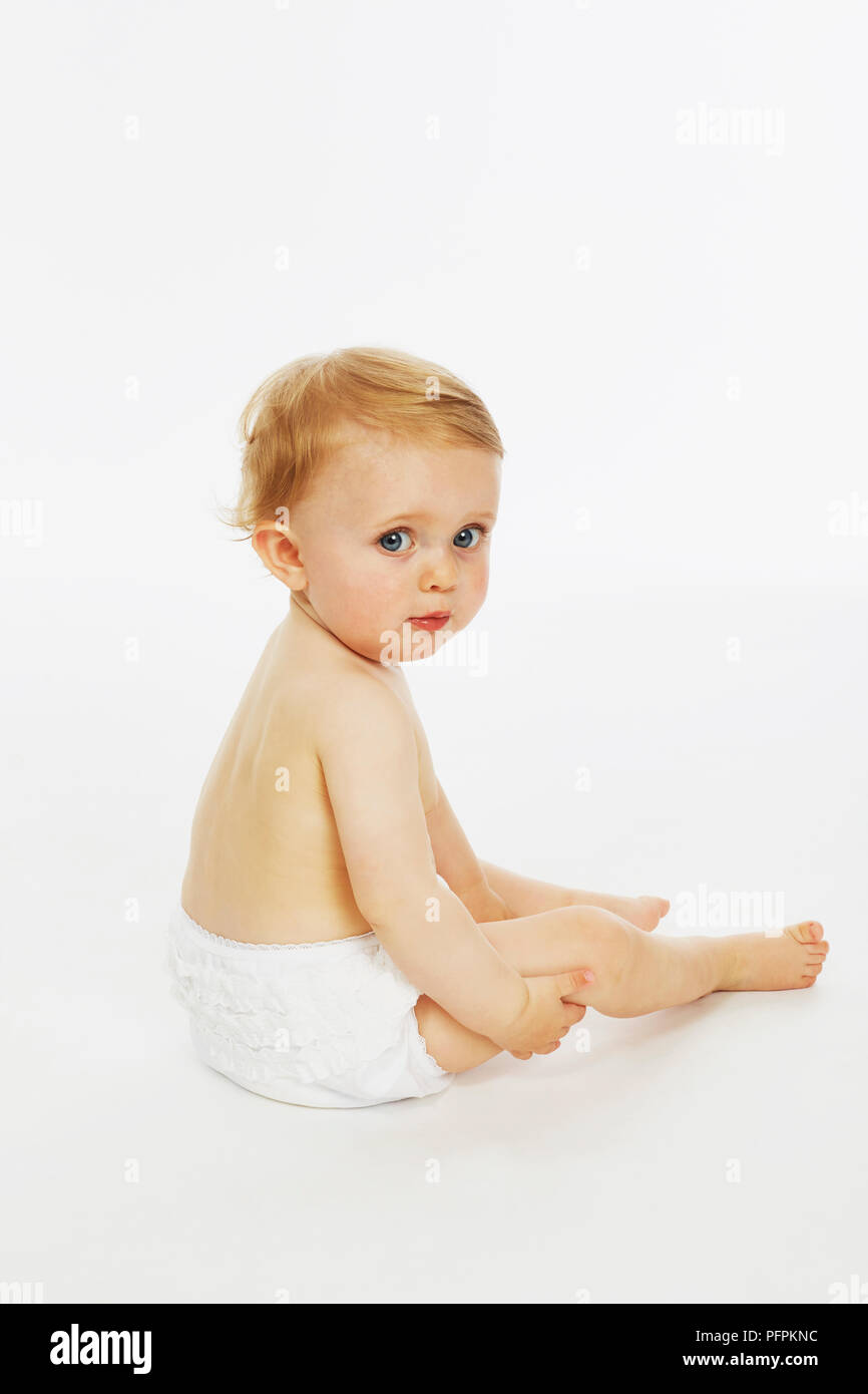 Baby in nappy sitting  (Model age - 9 months) Stock Photo