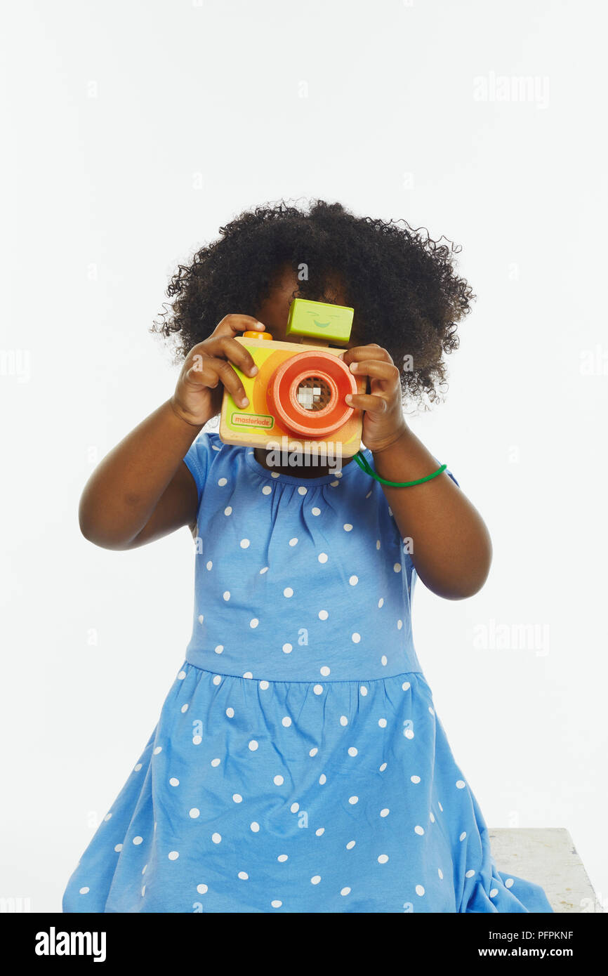 Little girl playing with toy camera (Model age - 2 years) Stock Photo