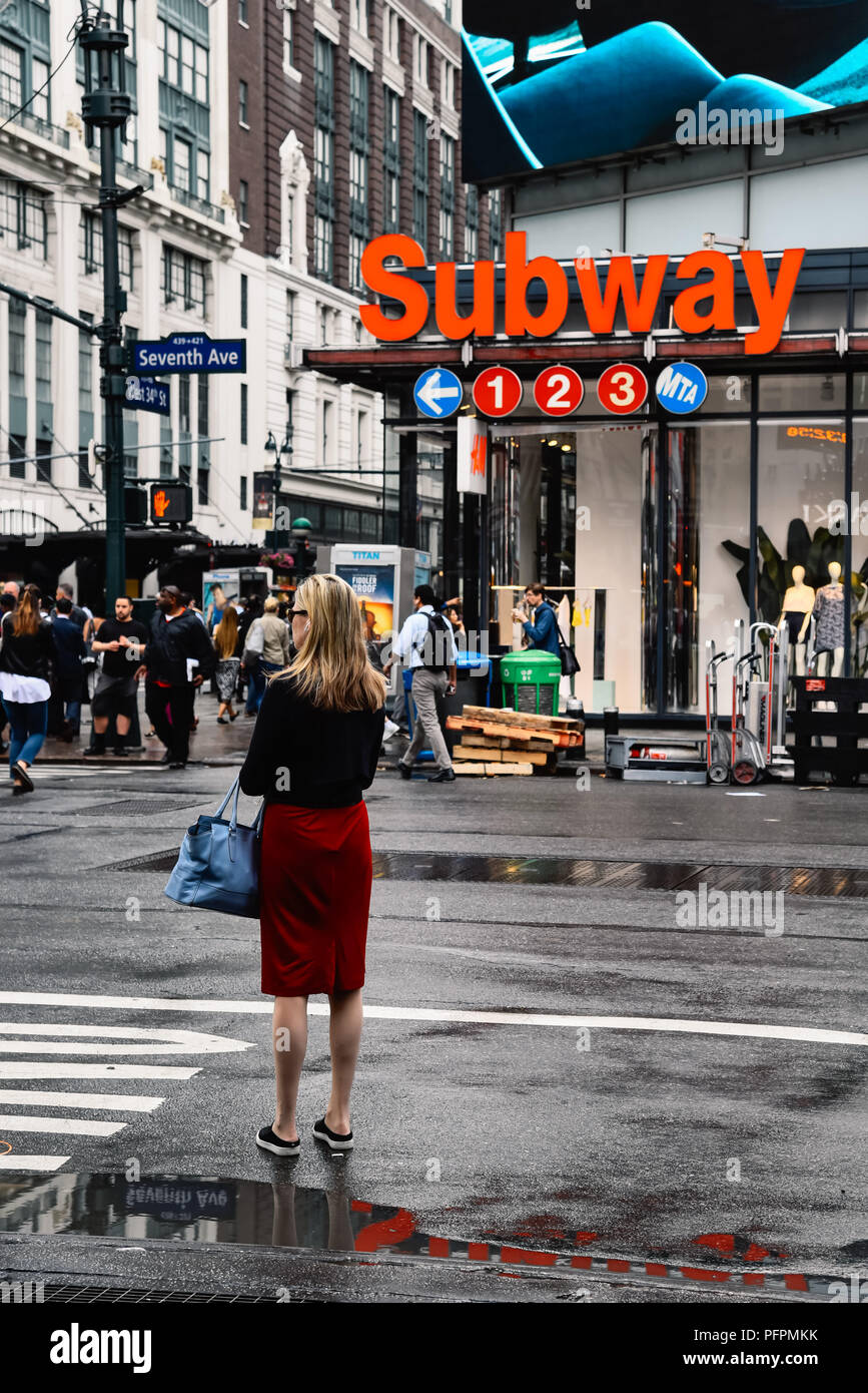 New York City, USA - June 21, 2018: Woman trying to get a taxi a rainy day in Manhattan. Stock Photo