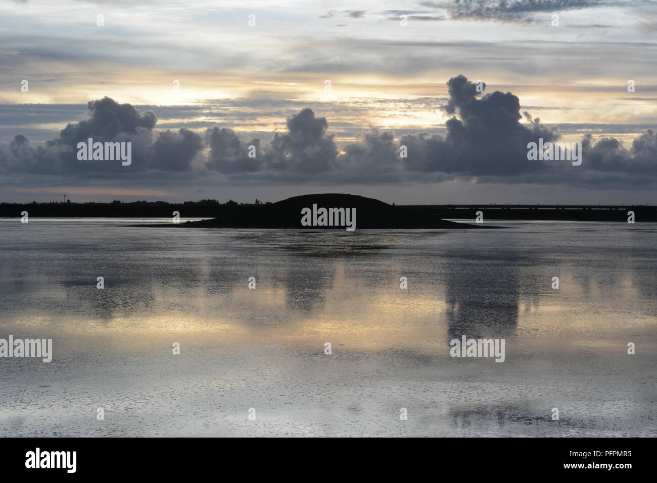 Mirror reflection of a grey sky in sea water Stock Photo - Alamy