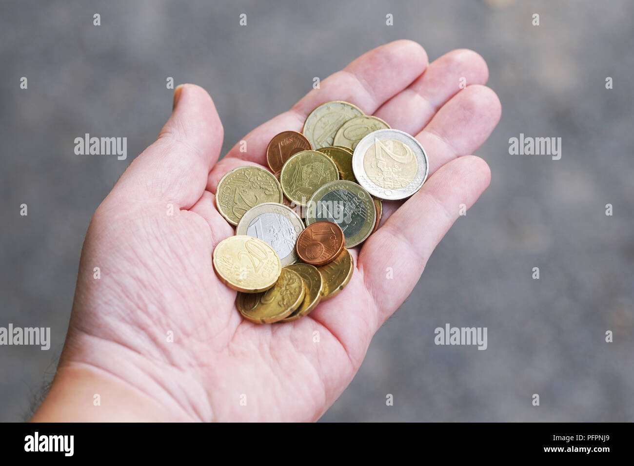 handful of small loose pocket change euro cent coins in palm of hand, money finance currency concept Stock Photo